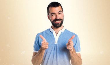 Mavi gömlek koyu sarı zemin üzerine açık işaret eden adamla