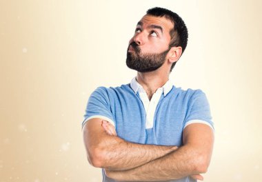 Mavi gömlek koyu sarı zemin üzerine şüpheleri olan adam