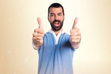 Adam koyu sarı zemin üzerine başparmak ile mavi gömlek ile