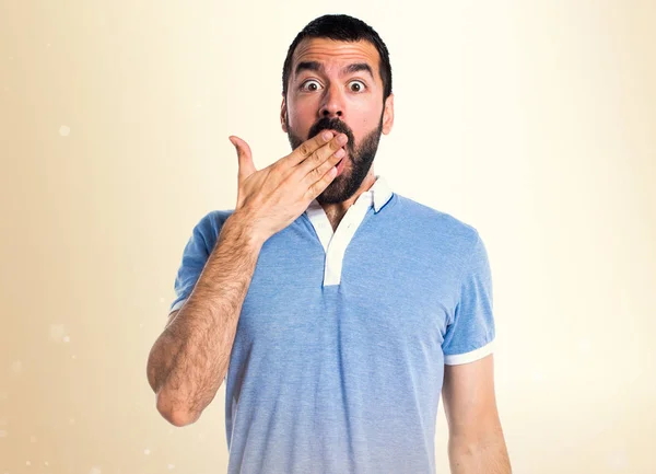 Hombre con camisa azul haciendo gesto sorpresa sobre fondo ocre — Foto de Stock