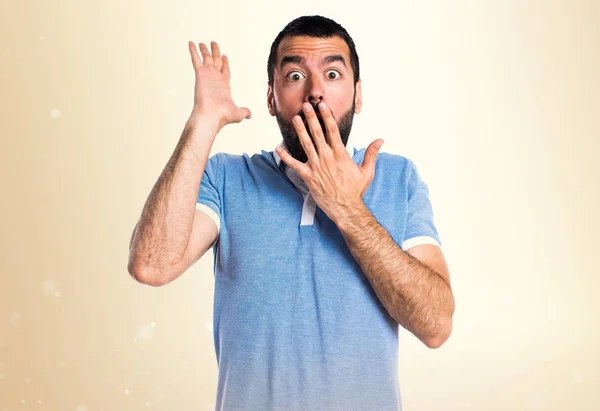 Homem com camisa azul fazendo gesto surpresa em outro fundo — Fotografia de Stock