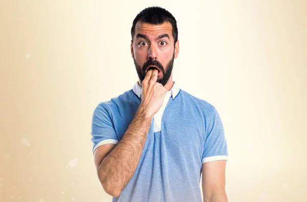 Mann mit blauem Hemd macht Erbrechen-Geste auf ockerfarbenem Hintergrund — Stockfoto