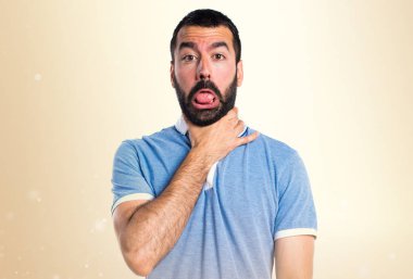 Adam kendini koyu sarı zemin üzerine boğulma mavi gömlek ile