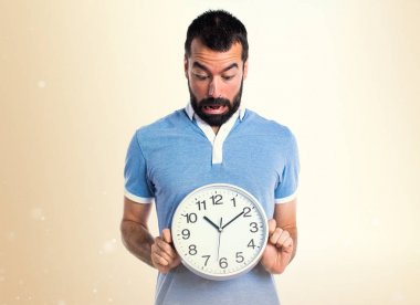 Mavi gömlek koyu sarı zemin üzerine saat tutan adamla