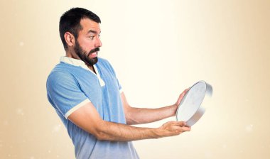 Mavi gömlek koyu sarı zemin üzerine saat tutan adamla