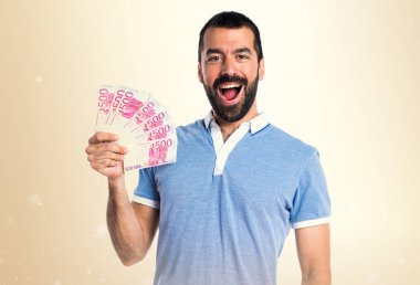 Mavi gömlek koyu sarı arka plan üzerinde bir sürü para alarak adamla