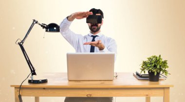 Ofisinde bir şey tutan Vr gözlükle işadamı 