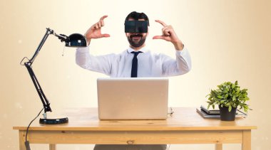 Ofisinde bir şey tutan Vr gözlükle işadamı 