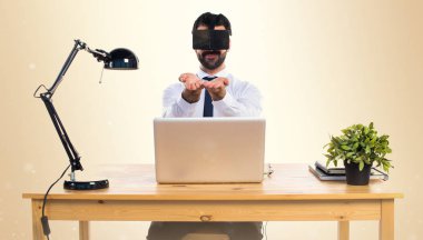 Ofisinde bir şey tutan Vr gözlükle işadamı 