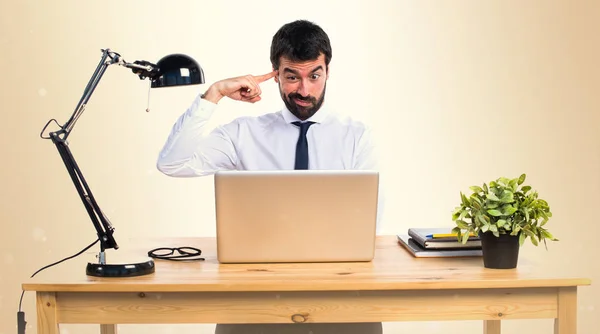 Businessman in his office making crazy gesture on ocher backgrou — Stock Photo, Image