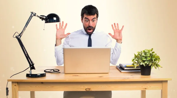 Businessman in his office doing surprise gesture on ocher backgr — Stock Photo, Image