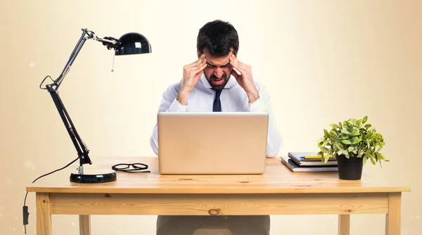 Frustrated businessman in his office on ocher background