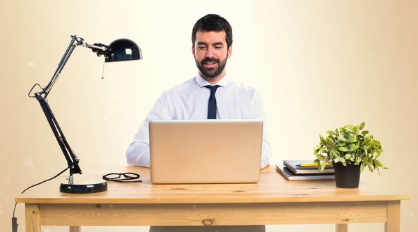 Empresario trabajando con laptot en su oficina en ocre backgroun — Foto de Stock