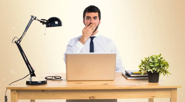 Businessman in his office covering his mouth on ocher background — Stock Photo, Image