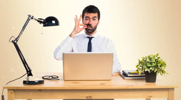 Zakenman in zijn kantoor maken-stilte gebaar op okergeel backgr — Stockfoto