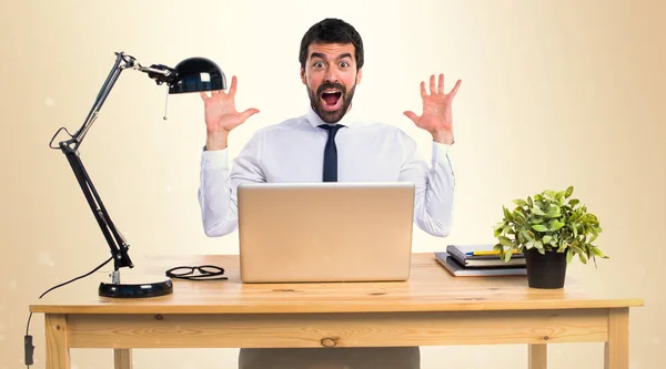 Businessman in his office doing surprise gesture on ocher backgr — Stock Photo, Image