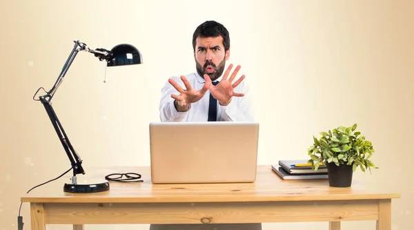 Frightened businessman in his office on ocher background