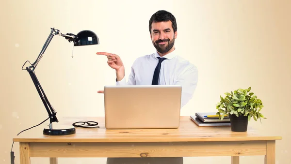 Geschäftsmann in seinem Büro zeigt auf die Seite auf ockerfarbenem Rücken — Stockfoto
