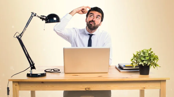 Homme d'affaires dans son bureau pensant sur fond ocre — Photo