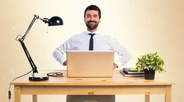 Επιχειρηματίας που εργάζεται με laptot στο γραφείο του στην ώχρα backgroun — Φωτογραφία Αρχείου