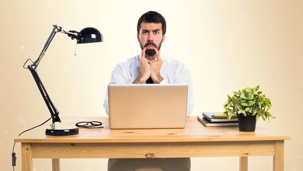 Triste hombre de negocios en su oficina sobre fondo ocre —  Fotos de Stock