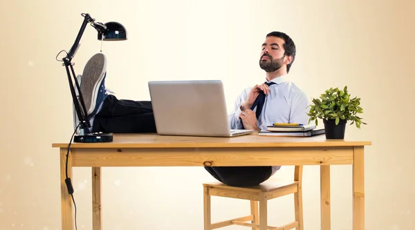 Бизнесмен работает с laptot в своем офисе на ocher backgroun — стоковое фото