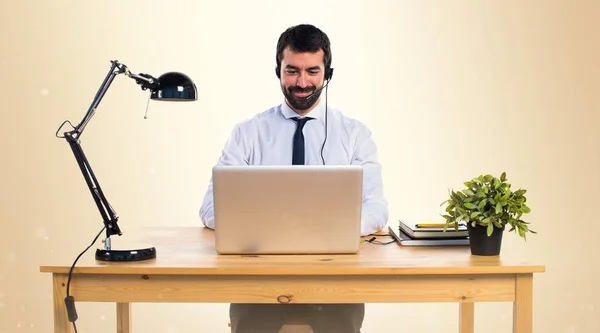 Jovem trabalhando com um fone de ouvido em outro fundo — Fotografia de Stock