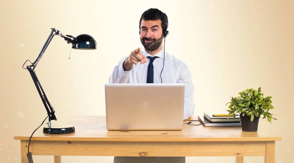 Jeune homme travaillant avec un casque pointant vers l'avant sur ocre — Photo