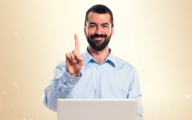 Adam bir koyu sarı arka plan üzerinde sayma dizüstü bilgisayar ile