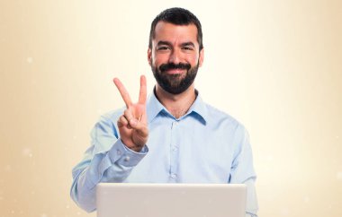 Adam iki koyu sarı zemin üzerine sayma dizüstü bilgisayar ile