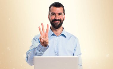 Adam üç koyu sarı zemin üzerine sayma dizüstü bilgisayar ile