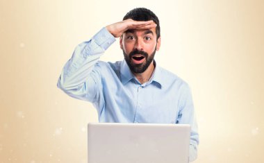 Adam bir şey Koyu sarı arka plan üzerinde gösterilen dizüstü bilgisayar ile