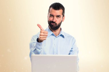 Adam koyu sarı zemin üzerine başparmak ile dizüstü bilgisayar ile