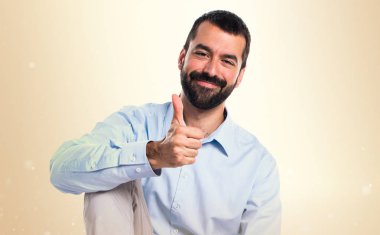 Koyu sarı zemin üzerine başparmak ile yakışıklı adam