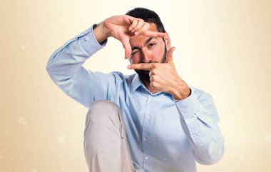 Yakışıklı adam onun parmaklarıyla koyu sarı arka plan üzerinde duruluyor