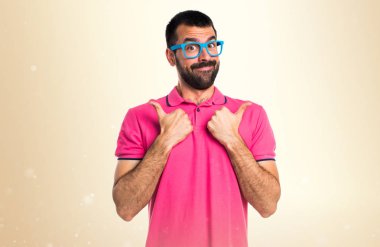 Koyu sarı zemin üzerine başparmak ile renkli giysili adam