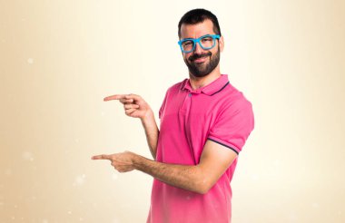 Renkli elbise lateral okra backg üzerinde işaret eden adamla