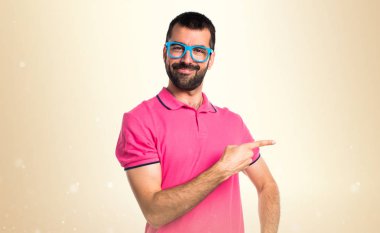 Renkli elbise lateral okra backg üzerinde işaret eden adamla