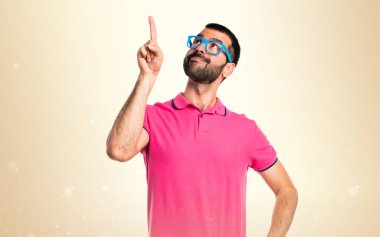 Adam yukarı dönük koyu sarı arka plan üzerinde renkli giysileri ile