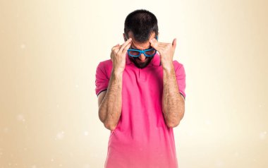 Koyu sarı arka plan üzerinde renkli giysileri ile sinirli adam