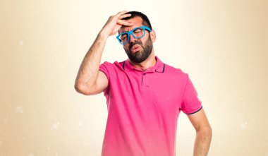 Koyu sarı arka plan üzerinde renkli giysileri ile sinirli adam