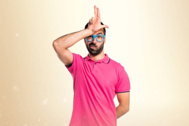 Renkli elbise koyu sarı arka plan üzerinde aptal tabelayı yapıyor adam