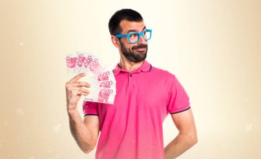 Adam bir sürü para üzerinde koyu sarı backgro alarak renkli giysileri ile