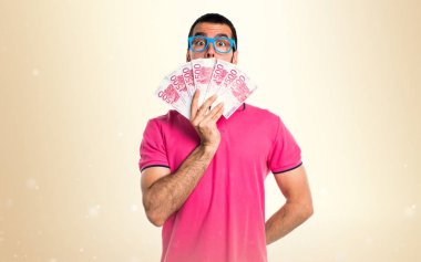 Adam bir sürü para üzerinde koyu sarı backgro alarak renkli giysileri ile