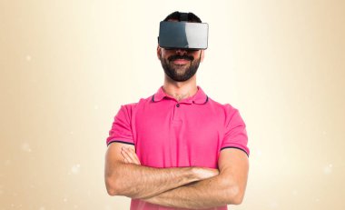 Adam Vr gözlükle koyu sarı arka plan üzerinde renkli giysileri ile