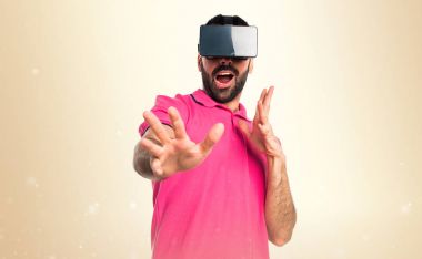 Adam Vr gözlükle koyu sarı arka plan üzerinde renkli giysileri ile