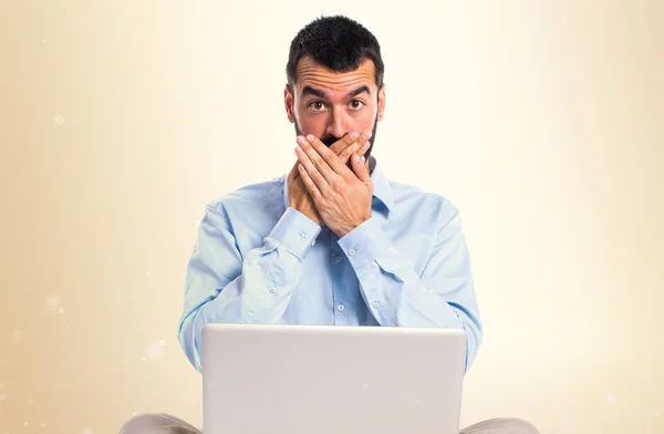 Man met laptop die betrekking hebben op zijn mond op okergeel achtergrond — Stockfoto