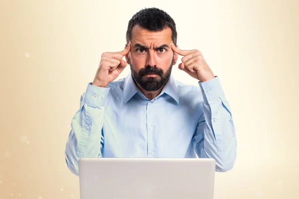 Mannen med laptop tänkande på ockra bakgrund — Stockfoto