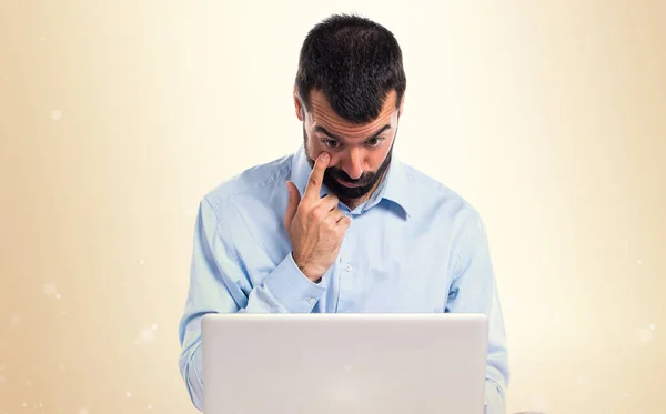 Man met laptop iets waarop met oker achtergrond — Stockfoto