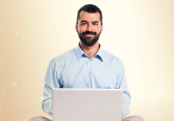 Man with laptop on ocher background — Stock Photo, Image